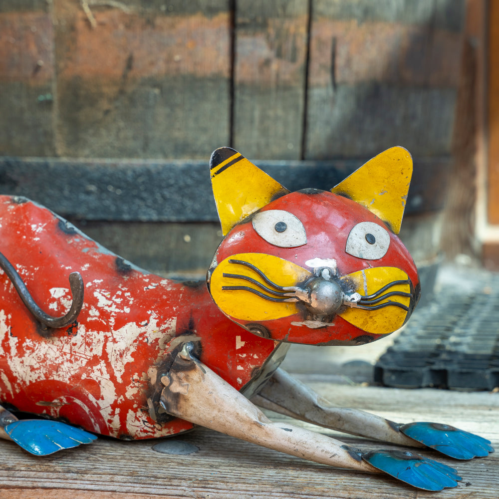 Vintage-style metal cat figurine with a rustic background