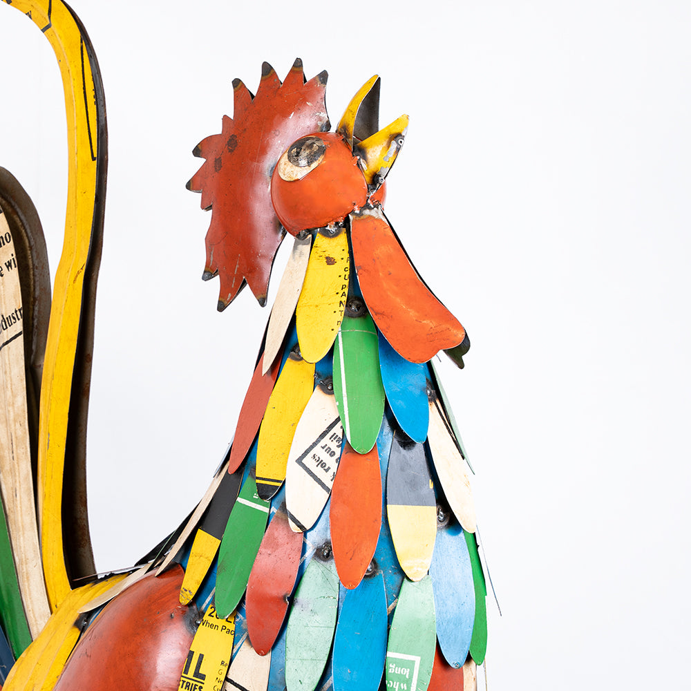 Colorful metal rooster sculpture on a white background