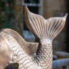 Close-up of a bronze fish sculpture with detailed scales and tail.