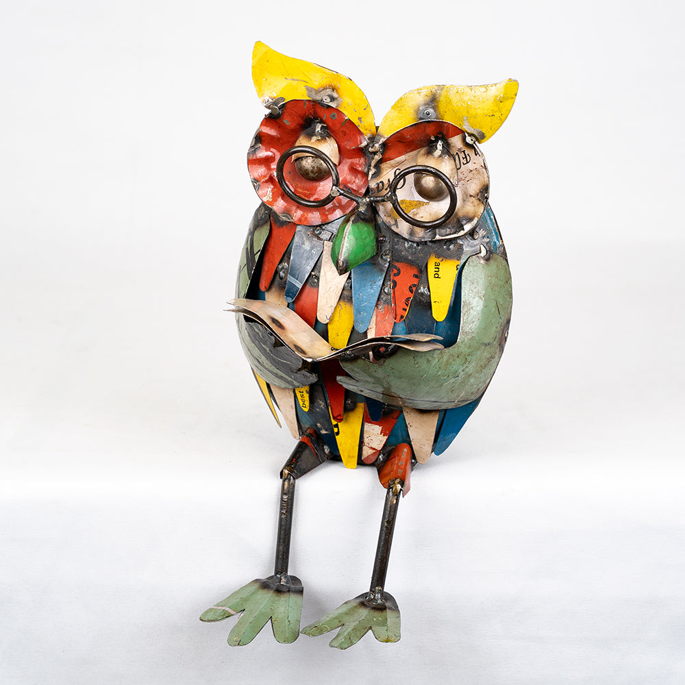Colorful owl sculpture made from recycled materials on a white background