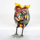 Colorful owl sculpture made from recycled materials on a white background