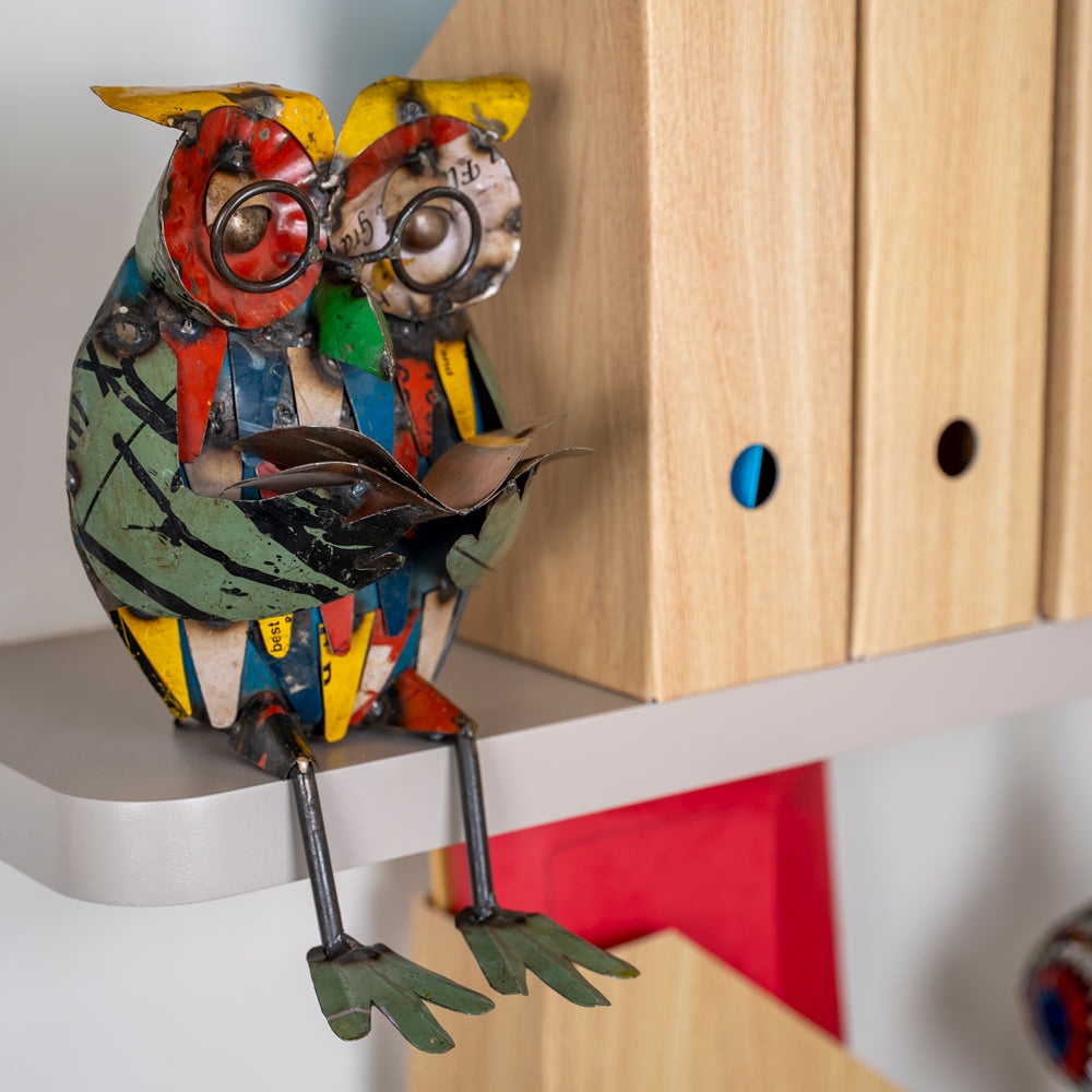 Colorful owl figurine on a shelf with a wooden cabinet in the background