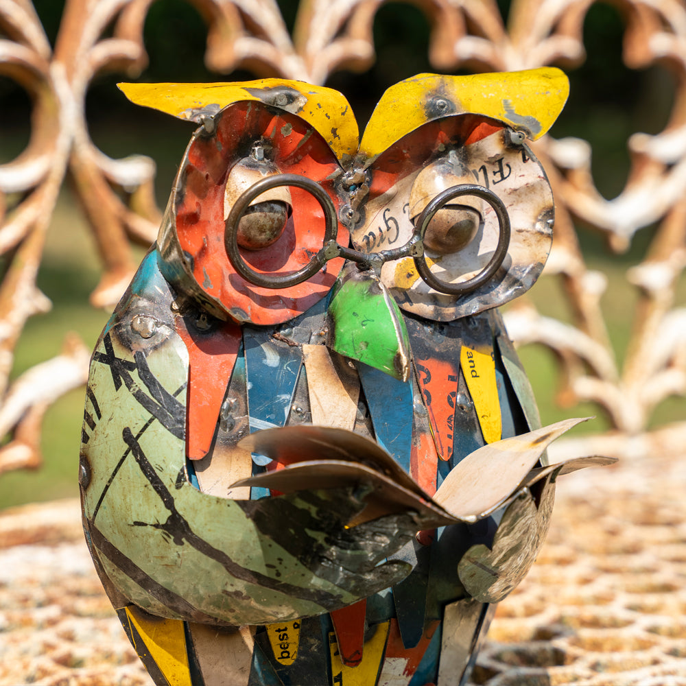 Colorful owl sculpture made from recycled materials against a natural background